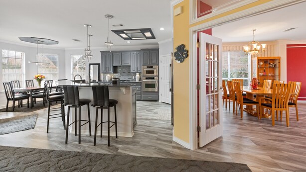 Une cuisine moderne avec des meubles gris, un îlot central et des luminaires suspendus.