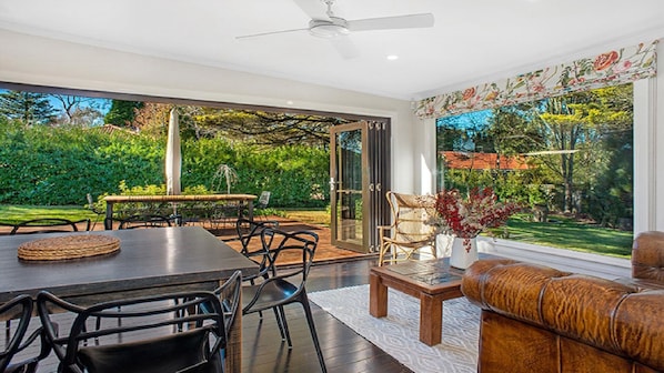 Relax in a spacious room with a dining area, leather sofa, and garden view.