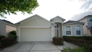 A single-story house with a garage, a small porch, and a well-maintained lawn. - 4BR Davenport Pool Home by Watson-222CH (Davenport)