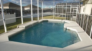 A swimming pool with a white deck, surrounded by a glass enclosure. - 4BR Davenport Pool Home by Watson-222CH (Davenport)