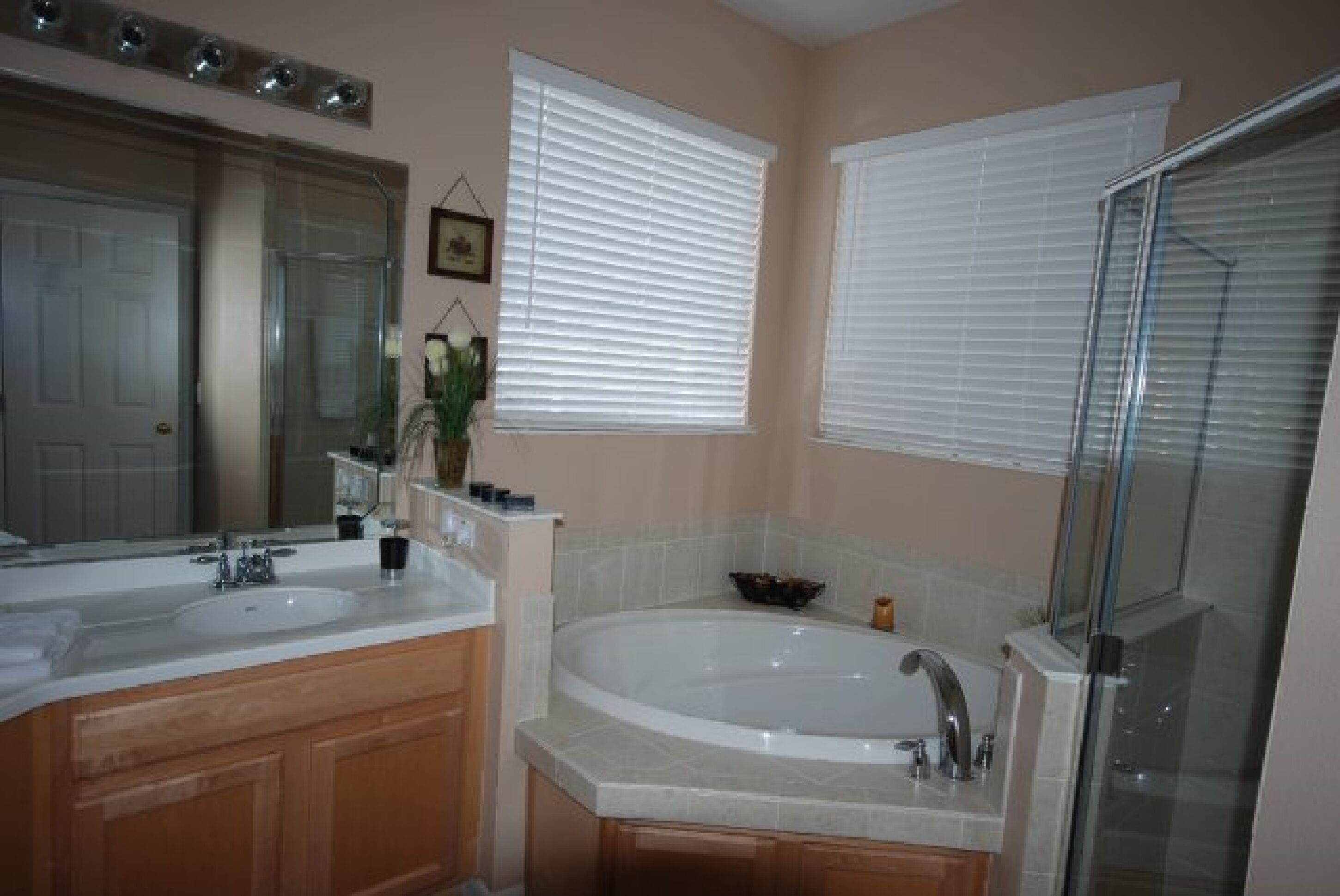 A bathroom with two sinks, a bathtub, and a glass shower enclosure.