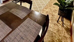 A living room with a sofa, a dining table with chairs, a ceiling fan, and a door. - PRIVATE DUPLEX #2 KING BED/Houston/Pasadena/ Hobby/Clear Lake/Galveston/ (Houston)