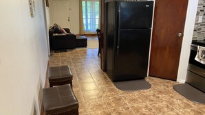 A kitchen with a black refrigerator, a wooden cabinet, and a door marked "home". - PRIVATE DUPLEX #2 KING BED/Houston/Pasadena/ Hobby/Clear Lake/Galveston/ (Houston)