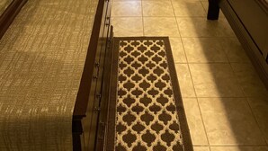 A narrow hallway with a bed at the end, a door on the left, and a small rug on the floor. - PRIVATE DUPLEX #2 KING BED/Houston/Pasadena/ Hobby/Clear Lake/Galveston/ (Houston)
