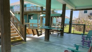 A covered outdoor area with wooden benches, picnic tables, and a staircase leading to an upper level. - Feelin’ Tip Sea - *Sleeps 10* Walking Distance to the beach! (Crystal Beach)