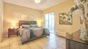 A bedroom with a bed, nightstands, a dresser, a vase with flowers, and a painting on the wall. - 4BR Davenport Pool Home by Watson-767OX (Davenport)