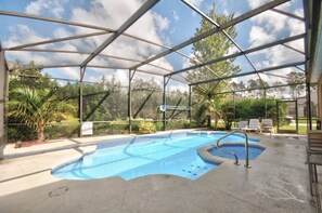Ein überdachter Pool im Freien mit Metallrahmen, umgeben von Grünflächen und Bäumen.