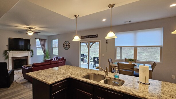 A modern kitchen with granite countertops, a built-in sink, and pendant lighting.