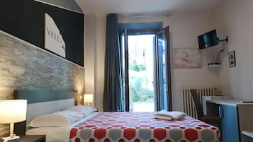 Habitación de hotel moderna con cama, mesita de noche, lámpara y vistas al exterior.