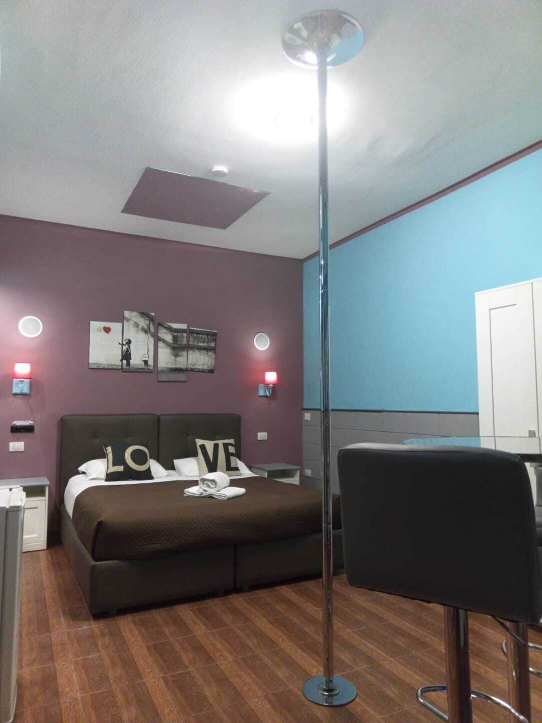 Une chambre d’hôtel moderne équipée d’un lit, d’un bureau et d’une lampe sur pied.