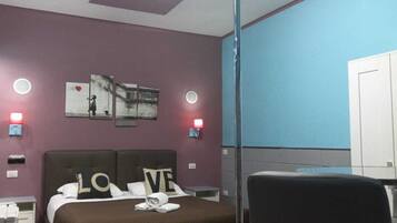 Une chambre d’hôtel moderne équipée d’un lit, d’un bureau et d’une lampe sur pied.