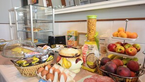 Un bufé de desayuno con diversas opciones de comida, incluyendo bollería, frutas y huevos.