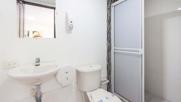 A bathroom with a white sink, toilet, and shower enclosure. - Hotel Avexi Suites By Geh Suites (Cartagena)