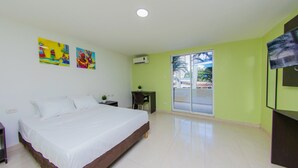 A bedroom with a bed, a desk, a chair, and a TV. - Hotel Avexi Suites By Geh Suites (Cartagena)