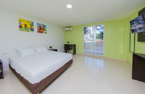 A bedroom with a bed, a desk, a chair, and a TV. - Hotel Avexi Suites By Geh Suites (Cartagena)