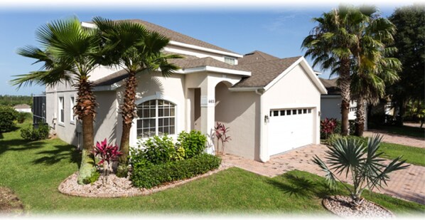A single-story house with a white exterior, a garage, and a well-maintained front yard with palm trees and shrubs.
