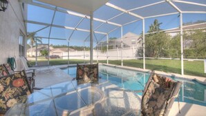 Ein Poolbereich mit Glasumrandung, ausgestattet mit einem Tisch und Stühlen, umrahmt von einem weißen Metallgestell.
