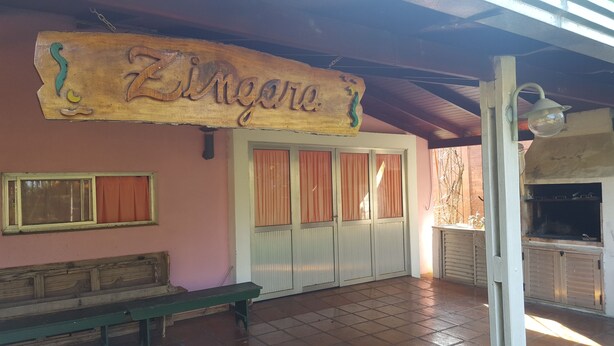 A wooden sign with the name 'Zingore' hanging above a door with pink curtains. - Beautiful house in Country steps from the Paraná River (Ituzaingo)