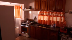 A kitchen with wooden cabinets, a stove, and a sink. - Beautiful house in Country steps from the Paraná River (Ituzaingo)