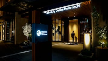 The exterior of Miyako City Osaka Homnachi hotel with a prominent entrance and illuminated signage.
