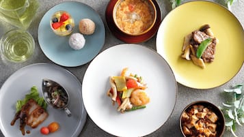 A variety of dishes on different plates, including seafood, vegetables, and desserts.