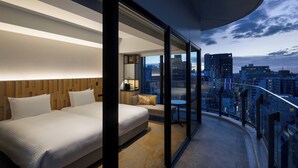 A modern hotel room with a large bed, a seating area, and a balcony with a city view. - Miyako City Osaka Hommachi (Osaka)
