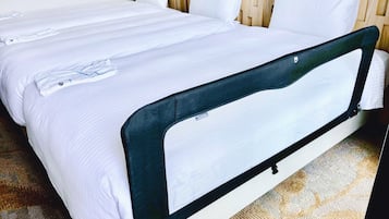 Uma cama de casal com cabeceira e peseira, um travesseiro e um cobertor.