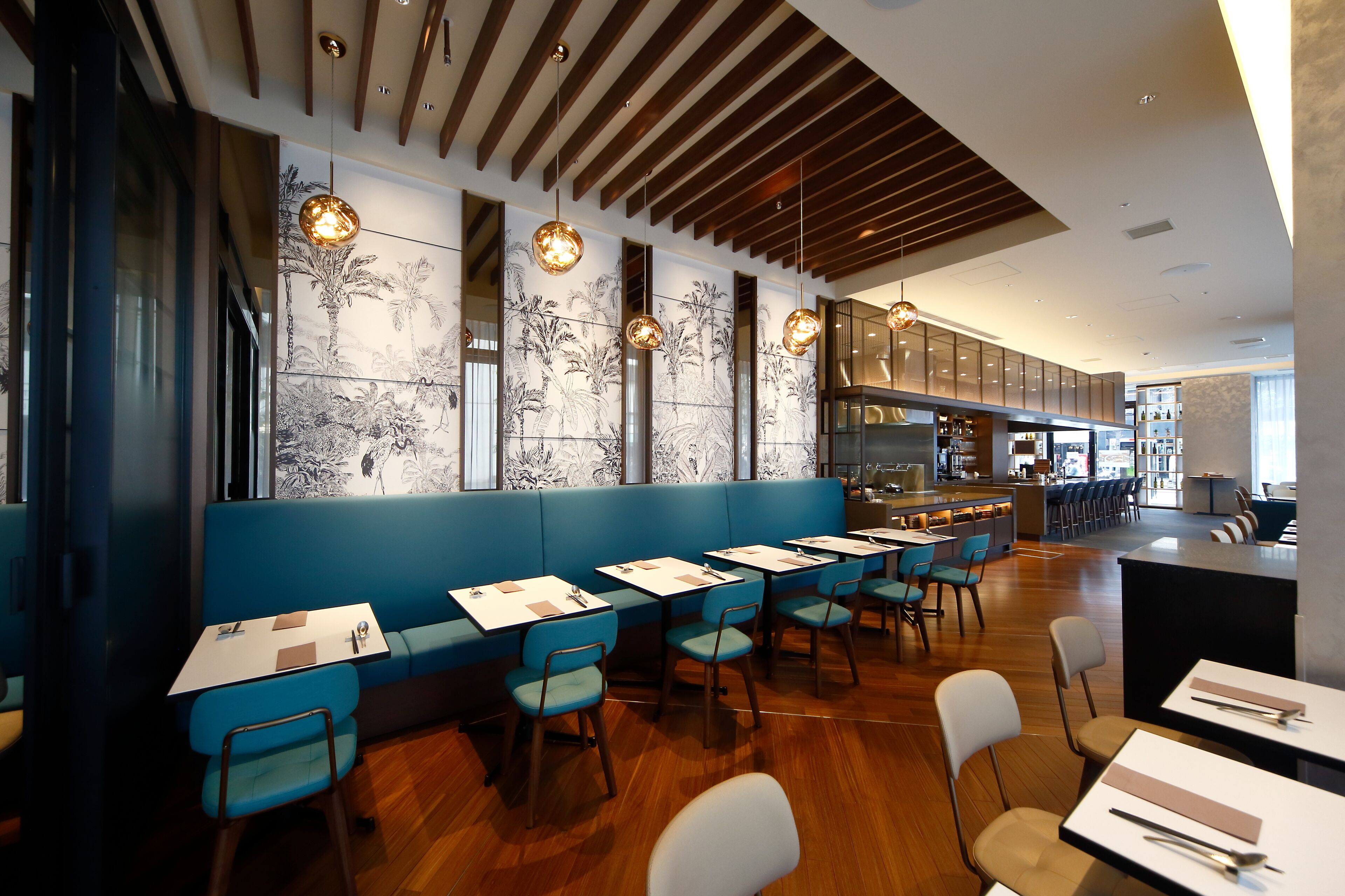 Un restaurant modern amb seients blaus i sòl de fusta.