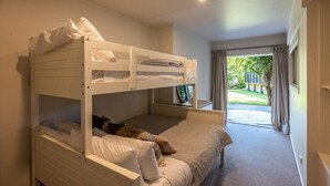 Habitación con literas y vista a un jardín por una ventana.