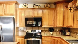 Una cocina con armarios de madera, un refrigerador de acero inoxidable, una estufa y un lavavajillas.