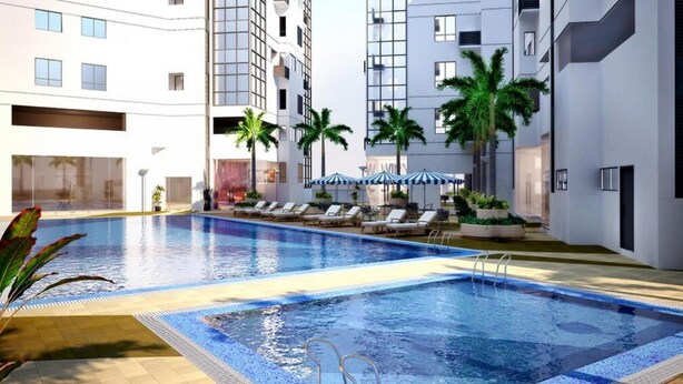 A swimming pool with lounge chairs and umbrellas, surrounded by palm trees and modern buildings. - Fort Victoria BGC Netflix 25M WiFi (Taguig)