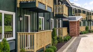 A row of modern, multi-story buildings with wooden balconies and brick accents. - The Lodge at Mount Snow (West Dover)