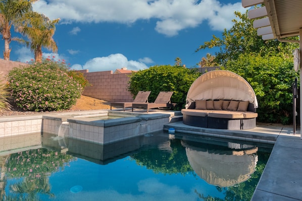 Saltwater pool, and hot tub with two lounge chairs and outdoor cabana lounge