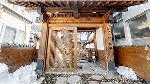 Un portón japonés tradicional con pilares de madera y techo de tejas.