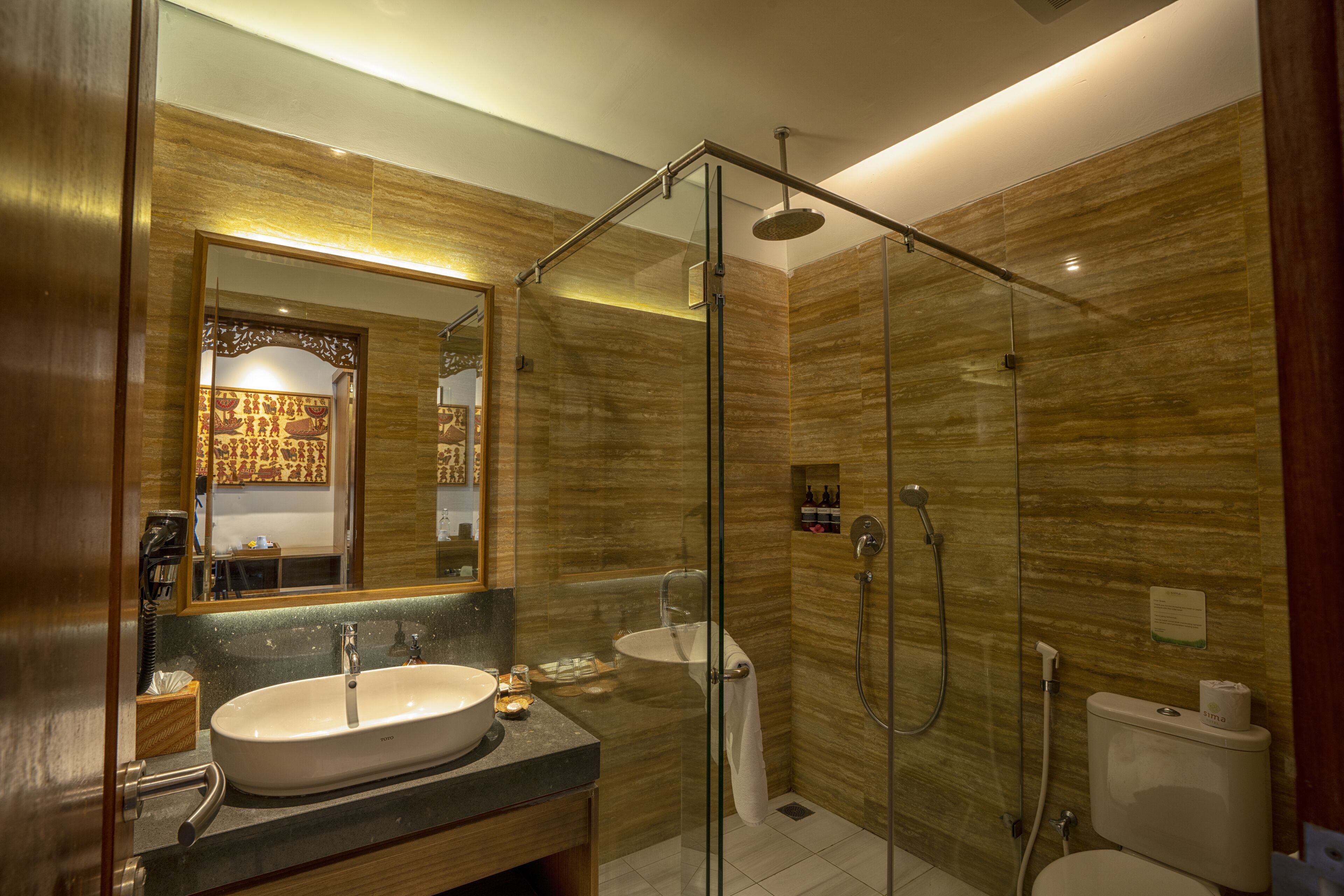 A modern bathroom with a glass-enclosed shower, a sink, and a toilet.
