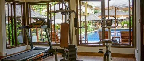 A gym with cardio equipment, weight machines, and a treadmill.