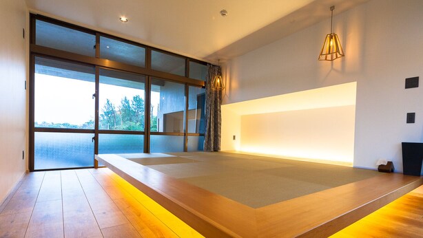 Una habitación moderna con una cama grande, vistas amplias a través de ventanas y un diseño de iluminación original a lo largo del borde de la cama.
