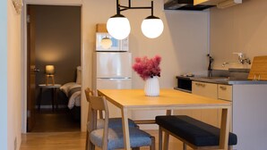Eine moderne Küche mit einem Holztisch, zwei Stühlen, einer Bank und einer Vase mit rosa Blumen.