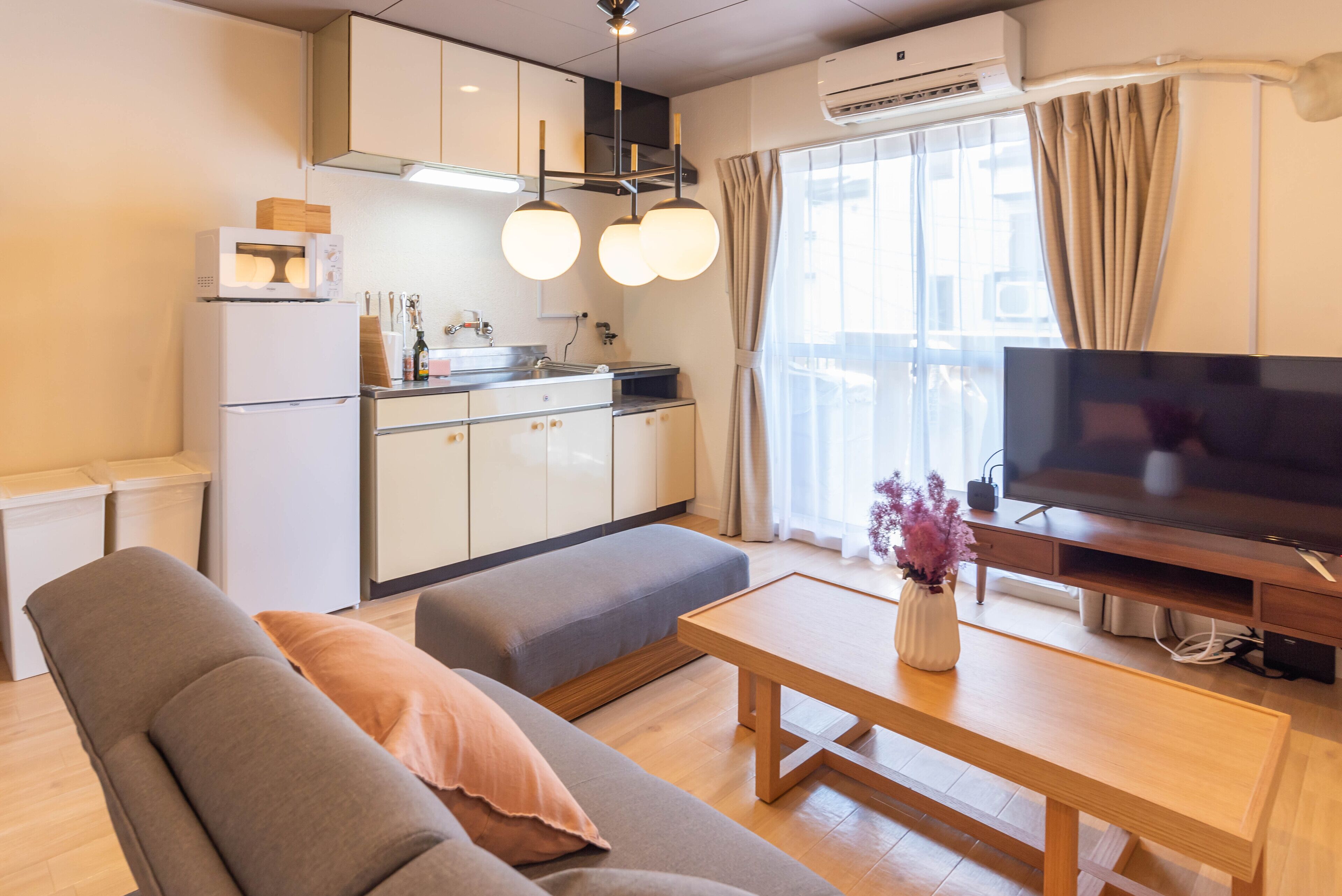 A modern living room with a sofa, a wooden coffee table, and a flat-screen TV.