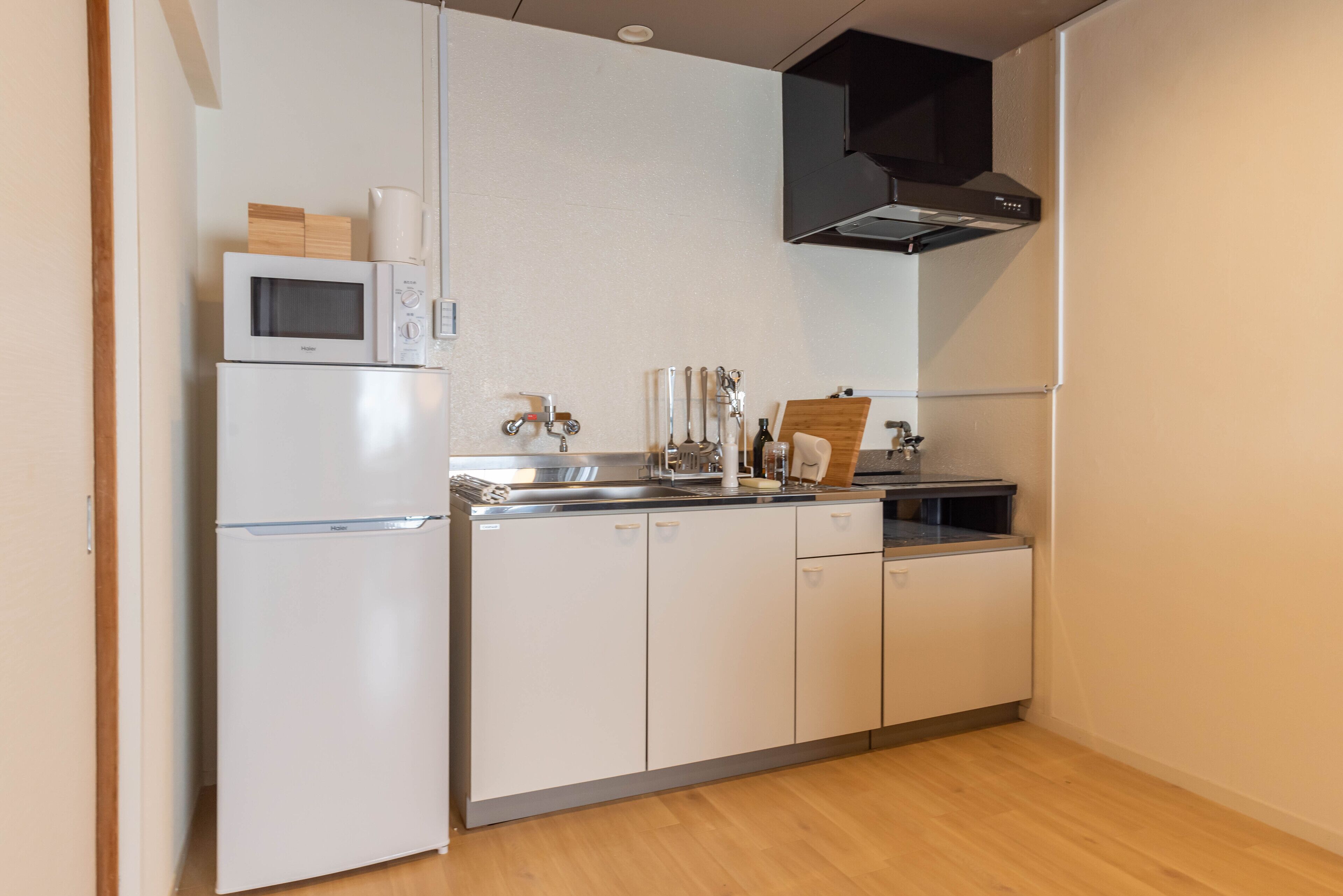 A compact kitchen with a microwave, refrigerator, sink, and stove.