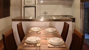 A modern kitchen with a central island, white cabinets, and a stainless steel range hood.