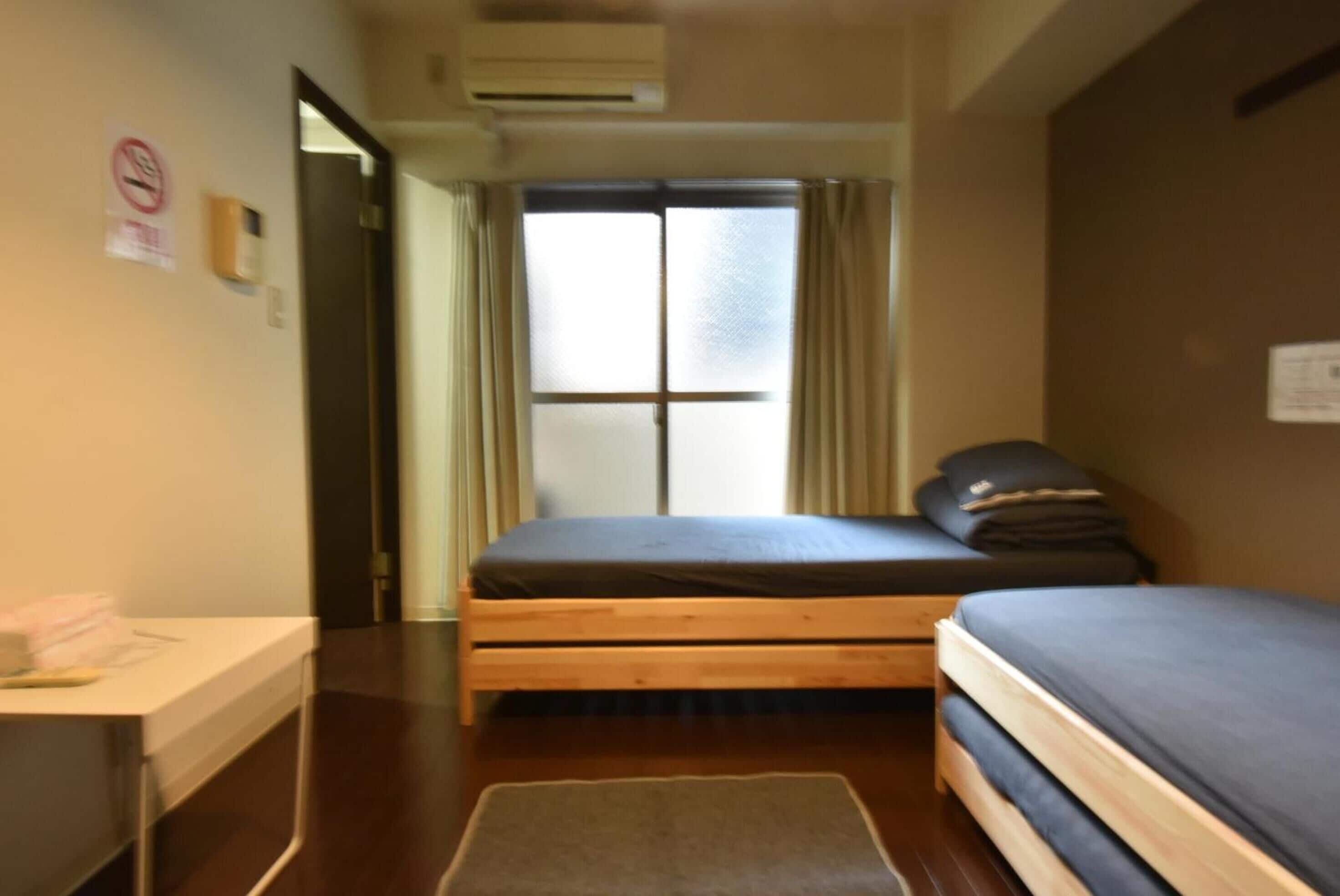 A room with a bed, a desk, and a window with curtains.