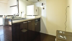 A compact kitchen with a sink, a white refrigerator, and a dishwasher. - Enzo Shin-Osaka C (Osaka)