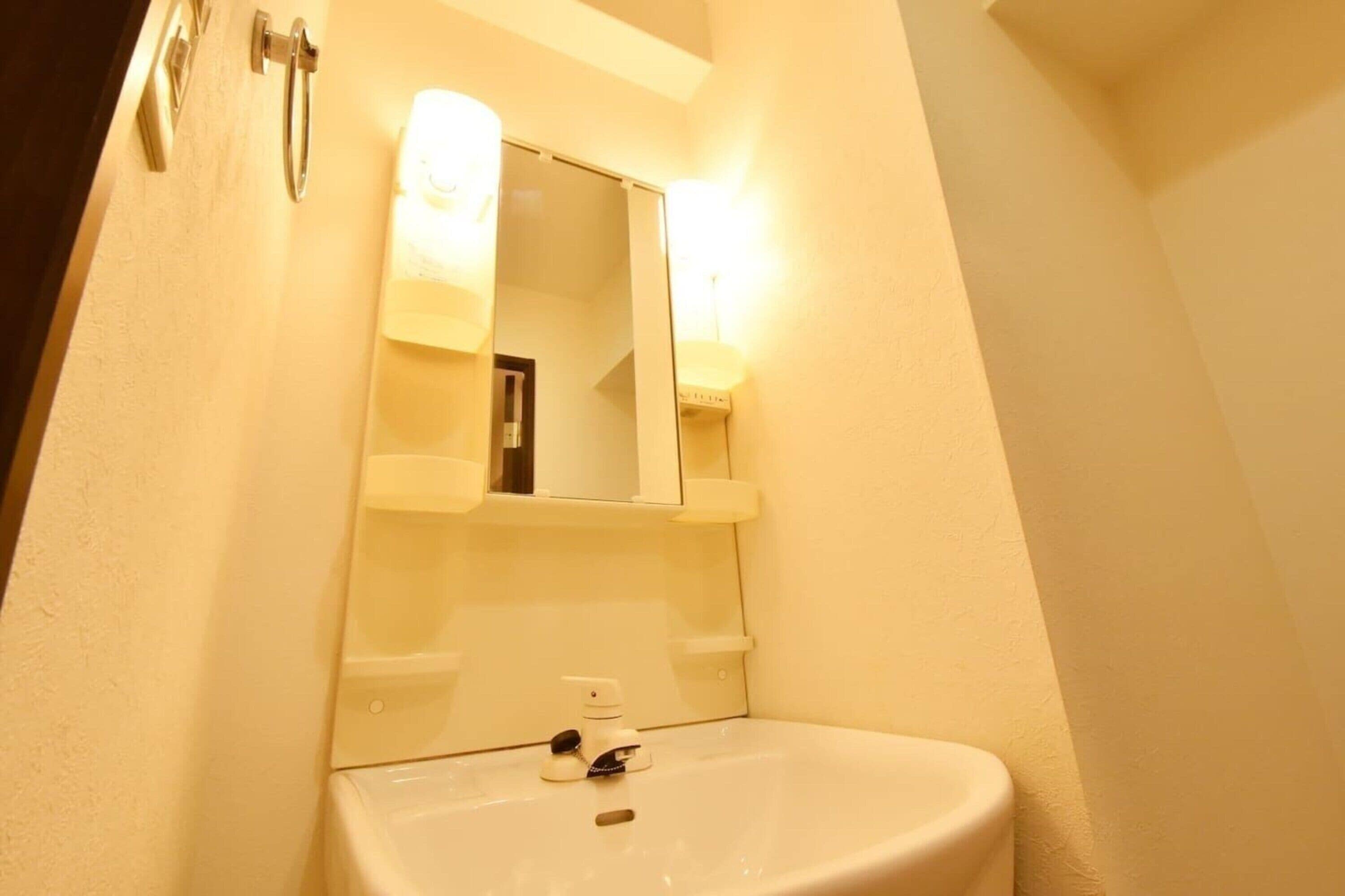 A bathroom with a sink, mirror, and towel rack.