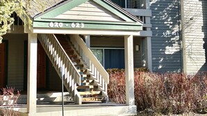 A two-story building with a covered porch and a staircase leading to the second floor. - Mountain Getaway (Mammoth Lakes)