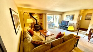 A cozy living room with a sofa, a coffee table, a fireplace, and a television. - Mountain Getaway (Mammoth Lakes)