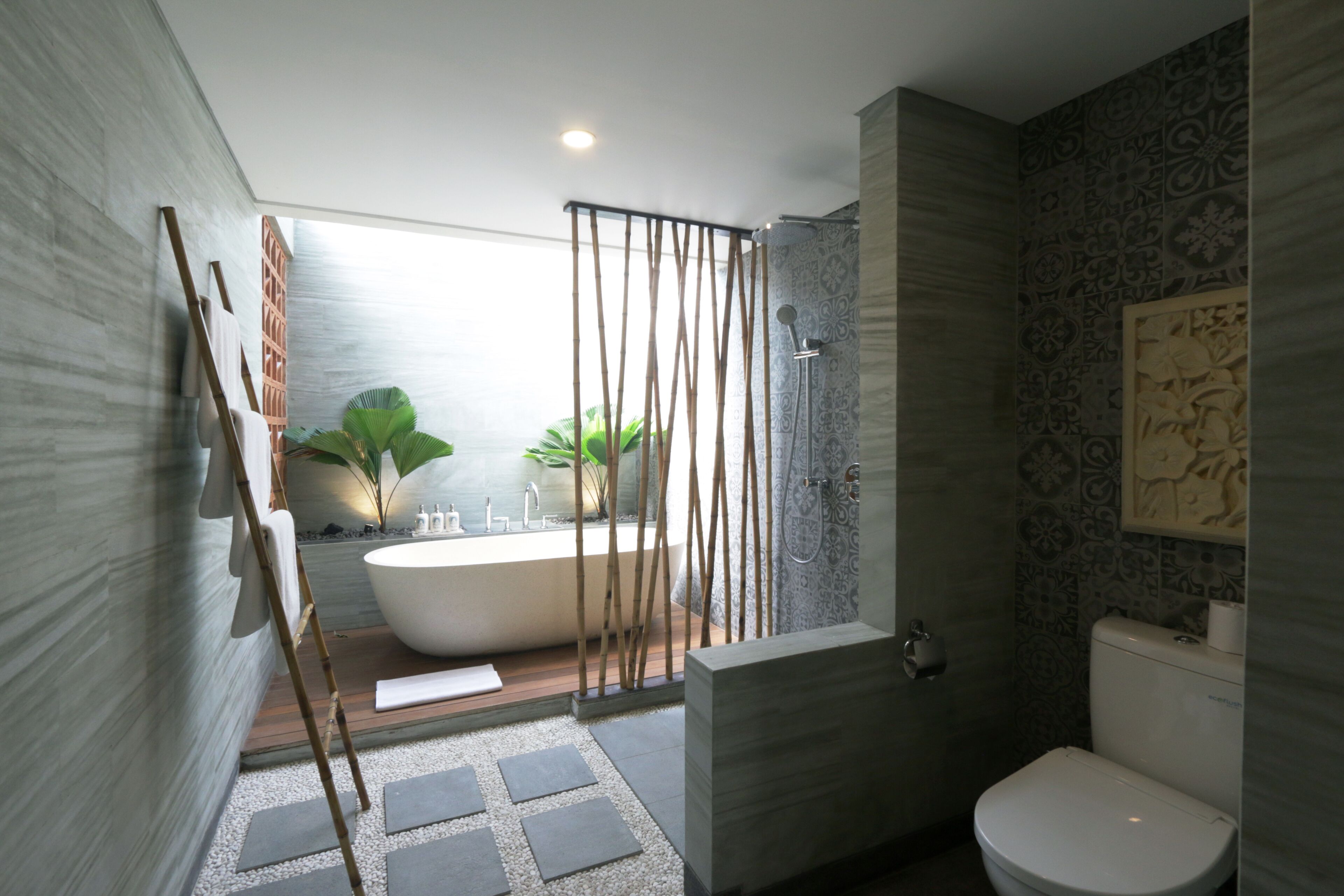 A modern bathroom with a freestanding bathtub, a shower area, and a toilet.
