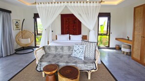 A bedroom with a bed, a sofa, a hanging chair, and a window with curtains. - Elite Cassia (Tibubeneng)