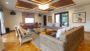 A modern living room with a large sofa, a glass coffee table, and a television. - Elite Cassia (Tibubeneng)