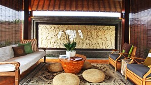 A room with a sofa, chairs, a coffee table, and a decorative wall. - Elite Cassia (Tibubeneng)